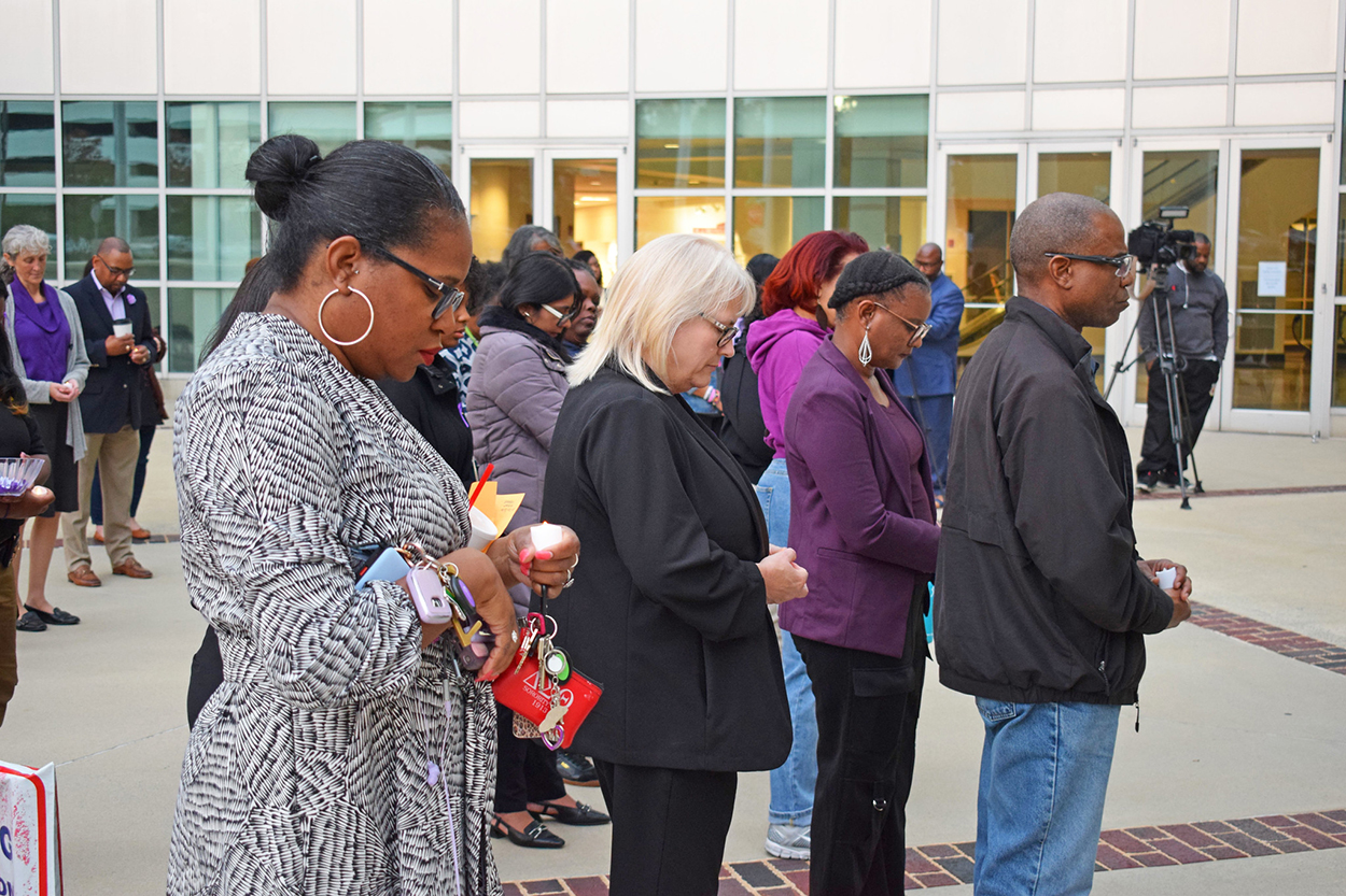 solemn people at a domestic violence vigil